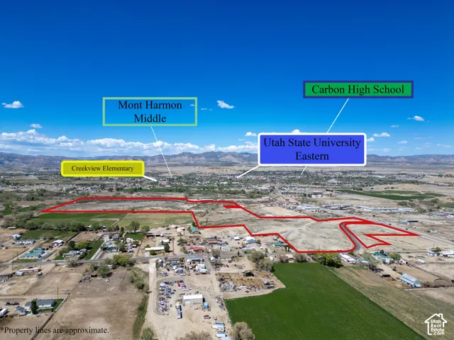 Aerial perspective of a large parcel of land featuring expansive acreage, natural terrain, and a mountain backdrop