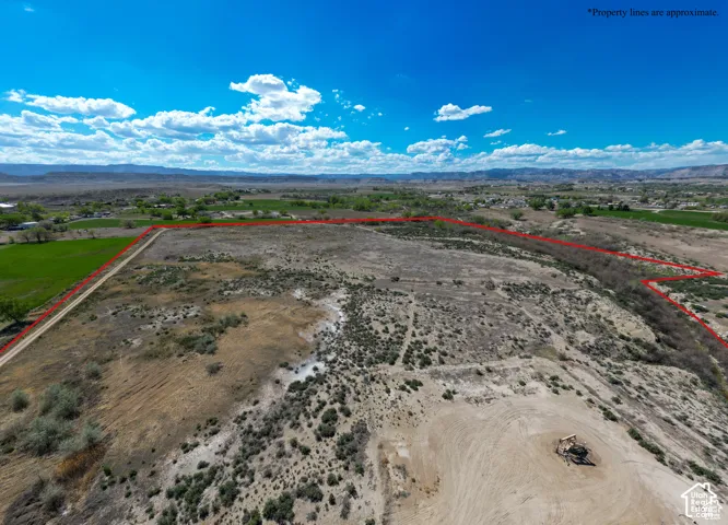 Expansive acreage featuring natural desert terrain, dirt access paths, and panoramic mountain backdrop