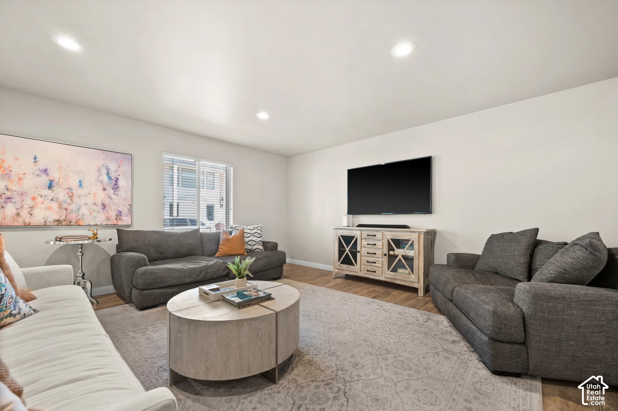 Interior living area featuring wood-finish flooring, neutral wall tones, and recessed lighting