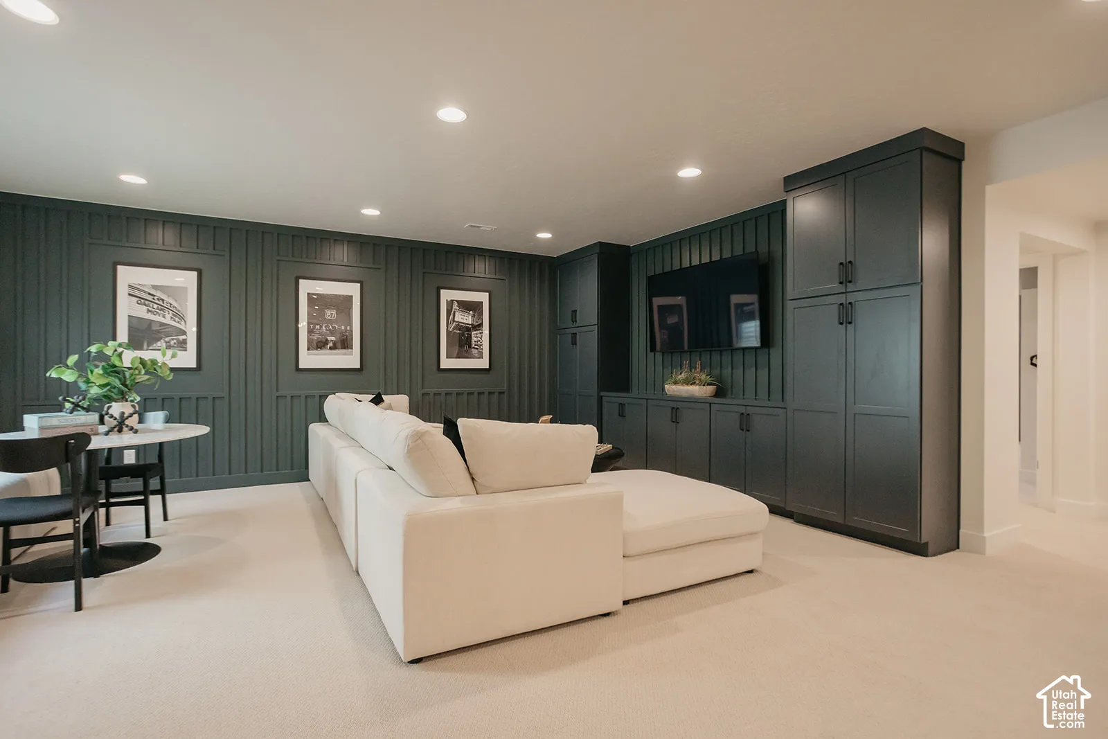 Vertical board-and-batten wall detailing, dark-toned custom built-in cabinetry, and recessed lighting
