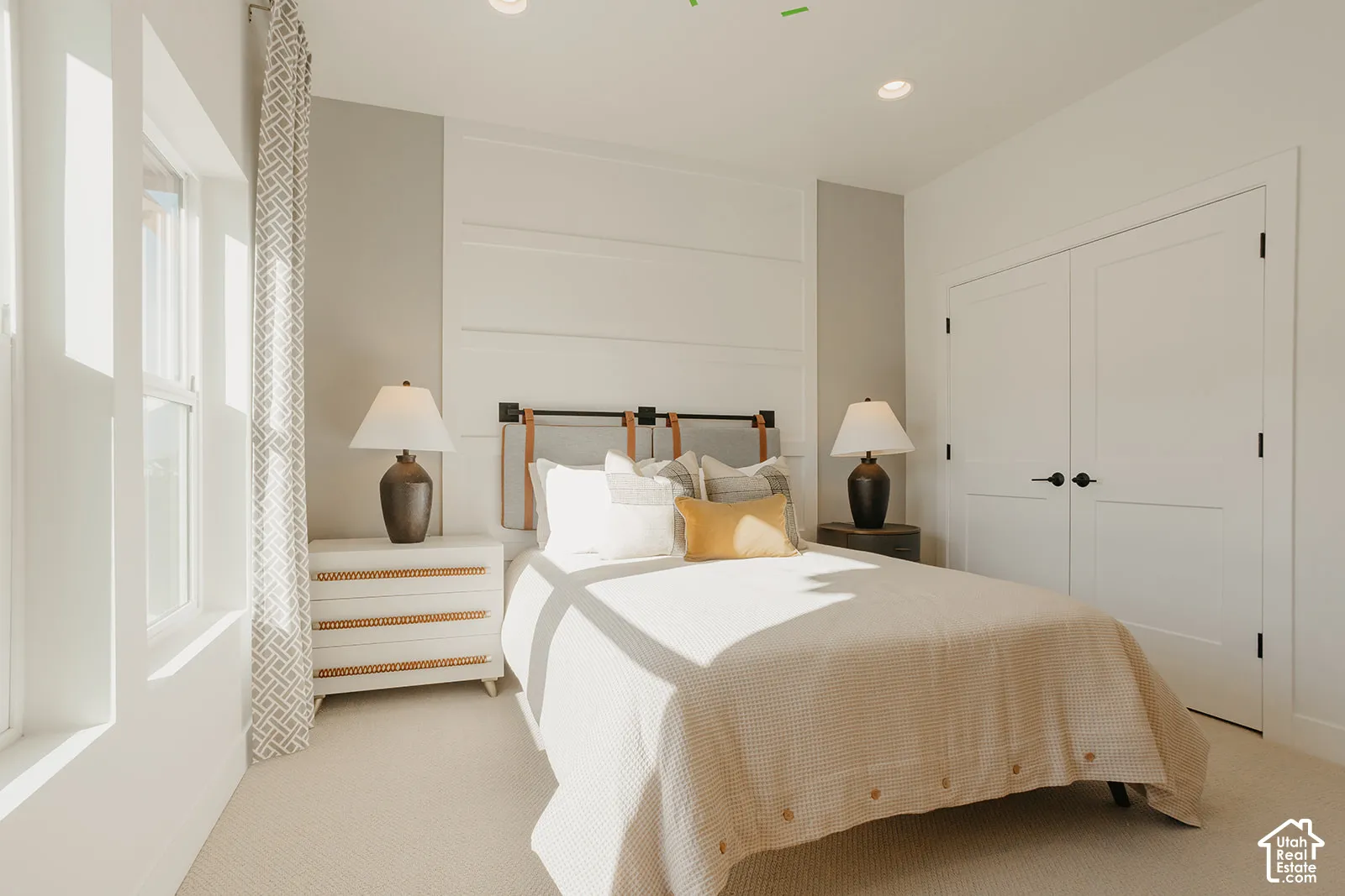 Interior room featuring white horizontal board-and-batten wall detailing, recessed ceiling lighting, neutral carpeting, and double-panel doors with matte black hardware