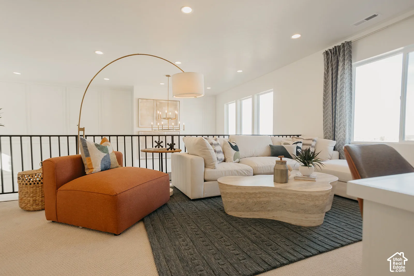 Open-concept room featuring recessed lighting, a matte black metal railing, and expansive windows