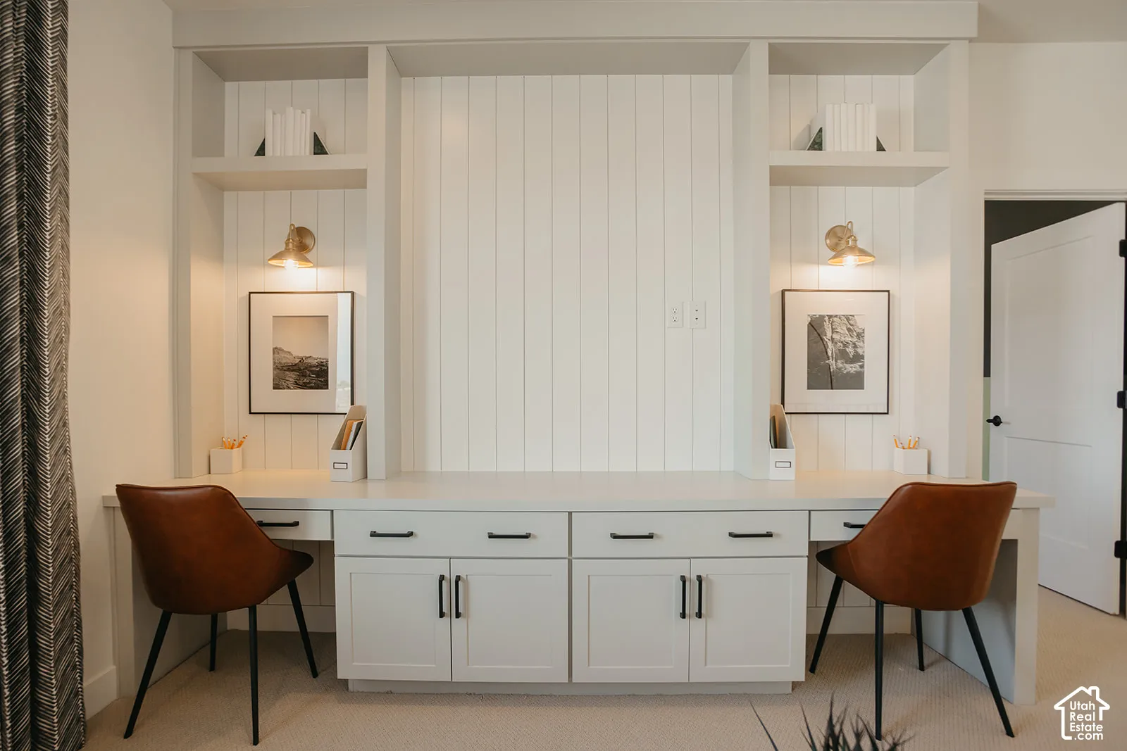 Built-in cabinetry featuring white shaker-style doors, matte black hardware, vertical shiplap detailing, integrated open shelving, and wall-mounted metal sconces