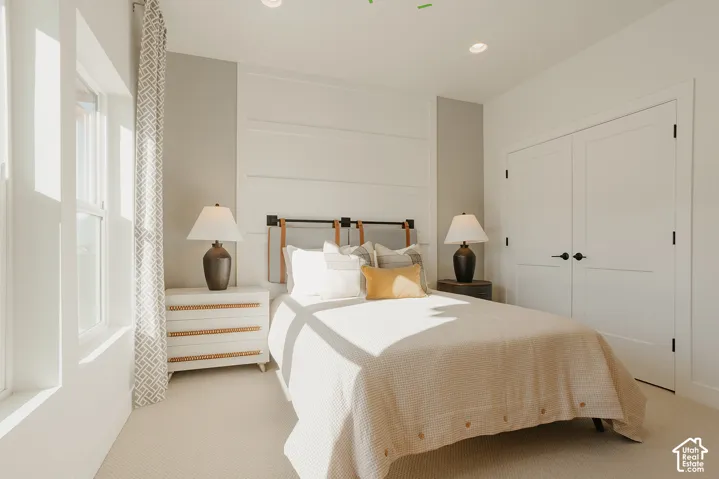 Interior room featuring white horizontal board-and-batten wall detailing, recessed ceiling lighting, neutral carpeting, and double-panel doors with matte black hardware