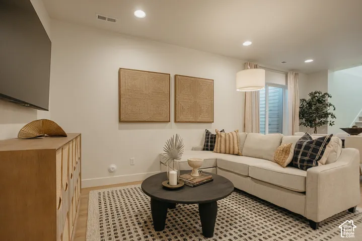 Neutral interior featuring recessed lighting, wood-finish flooring, and a glass-paneled door