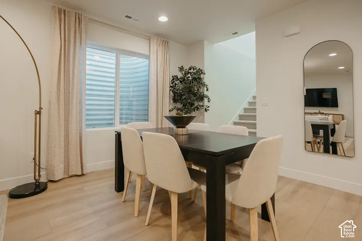 Wood-finish flooring, recessed lighting, and a window with a corrugated metal window well