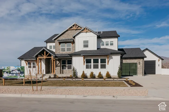 Two-story residence featuring a board-and-batten facade, stone veneer accents, timber-frame gable detailing, shingle roofing, and an attached multi-car garage