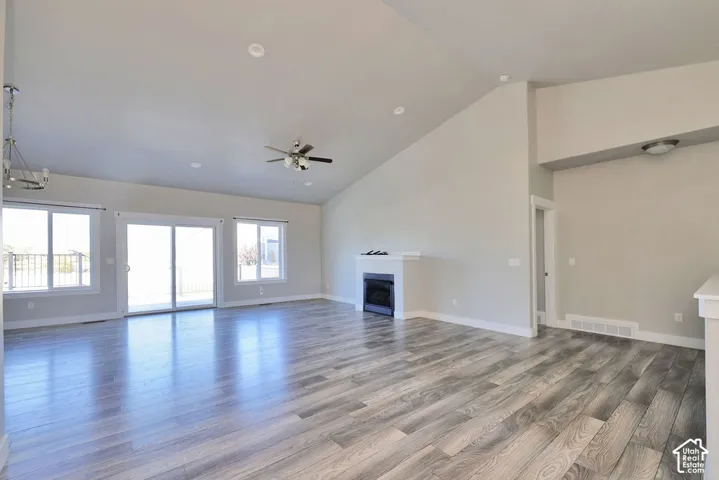 Vaulted ceilings, wood-finish flooring, built-in fireplace, sliding glass door, and recessed lighting