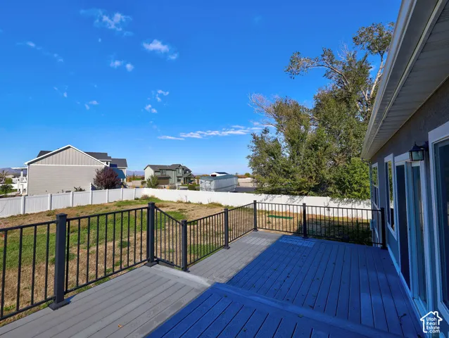 Elevated backyard deck with composite decking, black metal railings, and vinyl privacy fencing