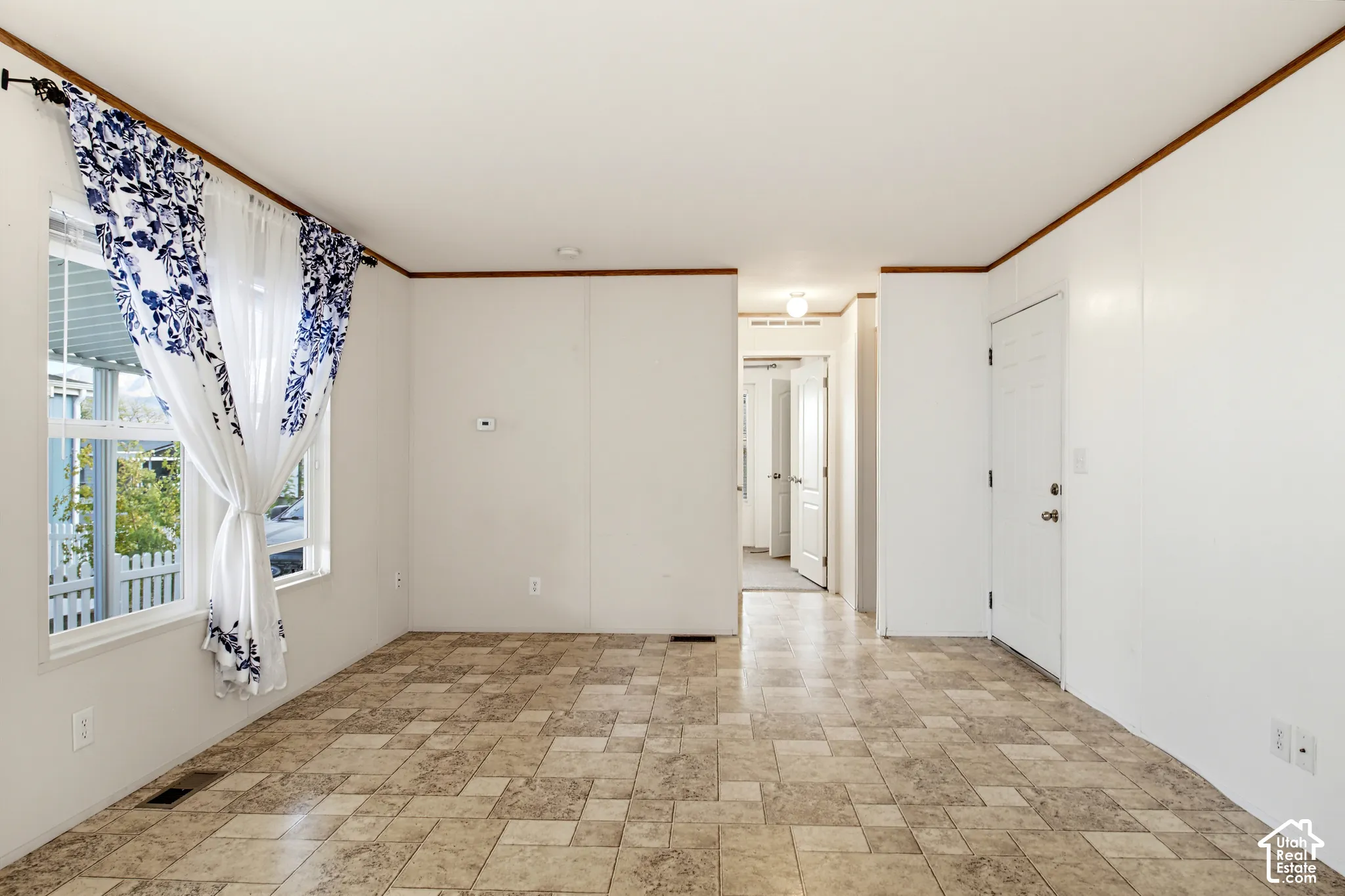 Interior space featuring multi-tonal tile flooring, neutral wall finishes, and trim detailing