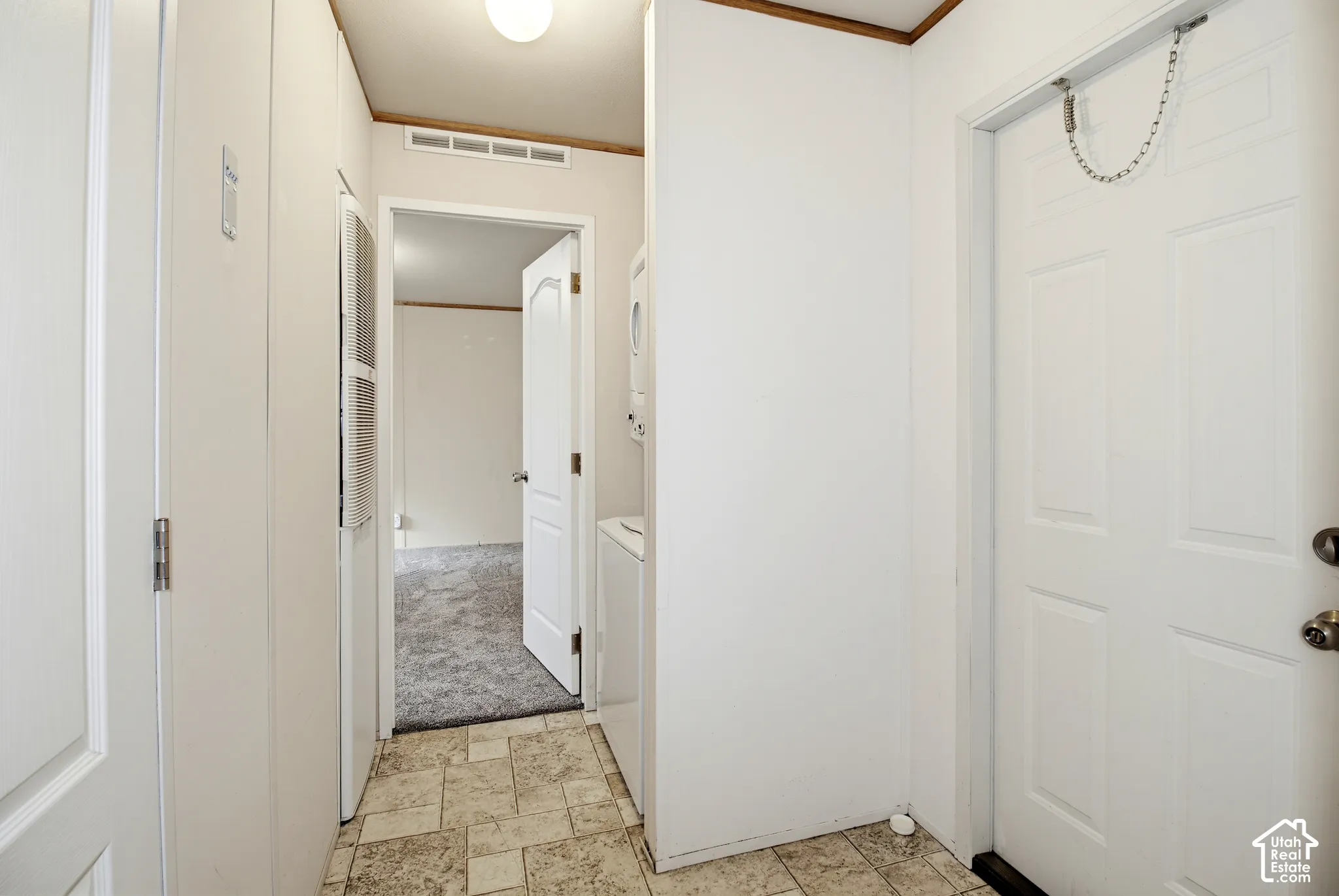 Utility area featuring tile flooring, six-panel interior doors, and a ceiling-mounted light fixture