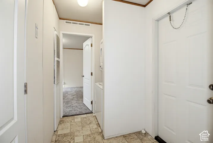 Utility area featuring tile flooring, six-panel interior doors, and a ceiling-mounted light fixture