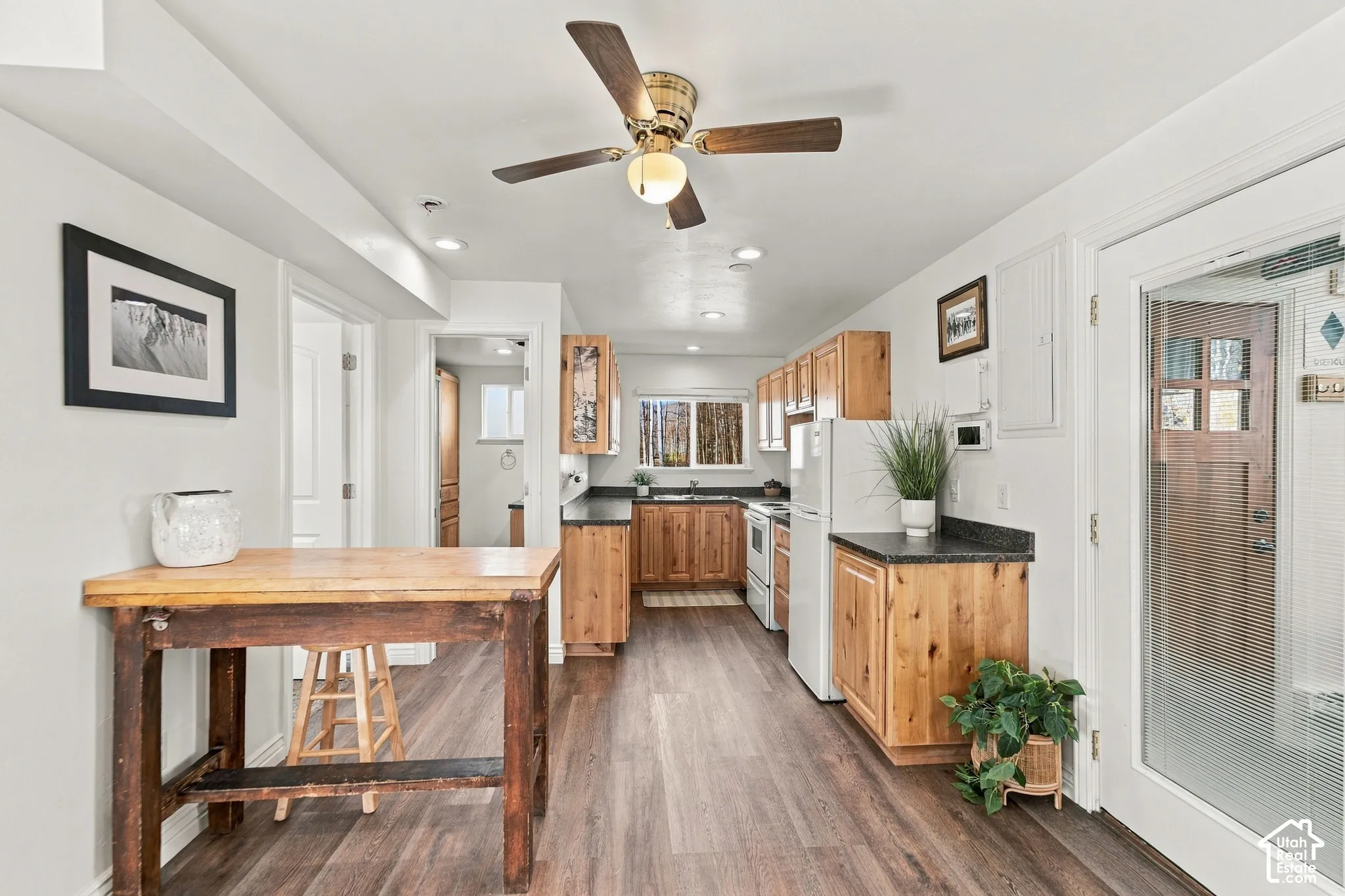 Kitchen featuring wood-finish cabinetry, dark solid-surface countertops, wood-finish flooring, recessed lighting, and a ceiling fan with integrated lighting