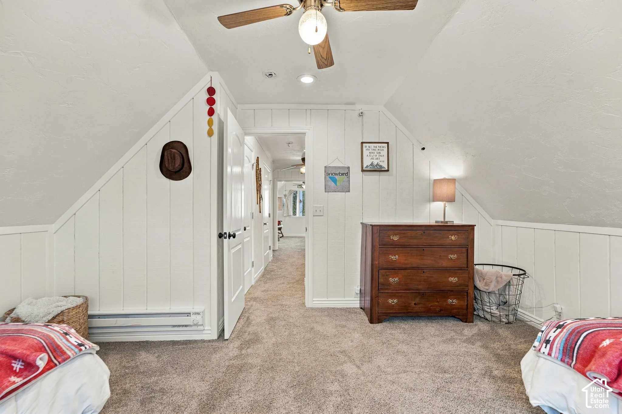 Vaulted ceilings featuring vertical wood paneling, carpeted flooring, and a ceiling-mounted light fixture with fan