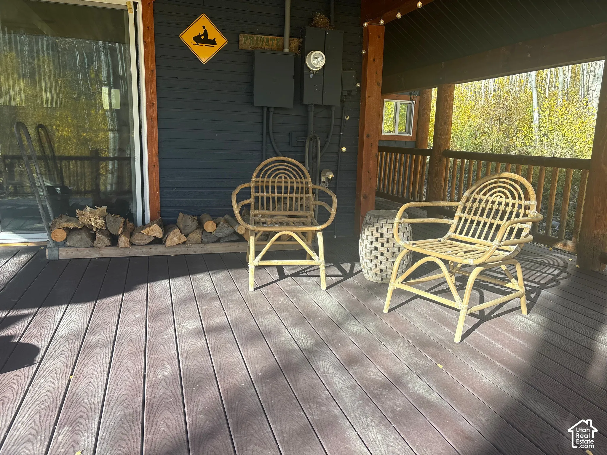 Covered deck featuring wood-finish decking, horizontal lap siding, and a wooden balustrade