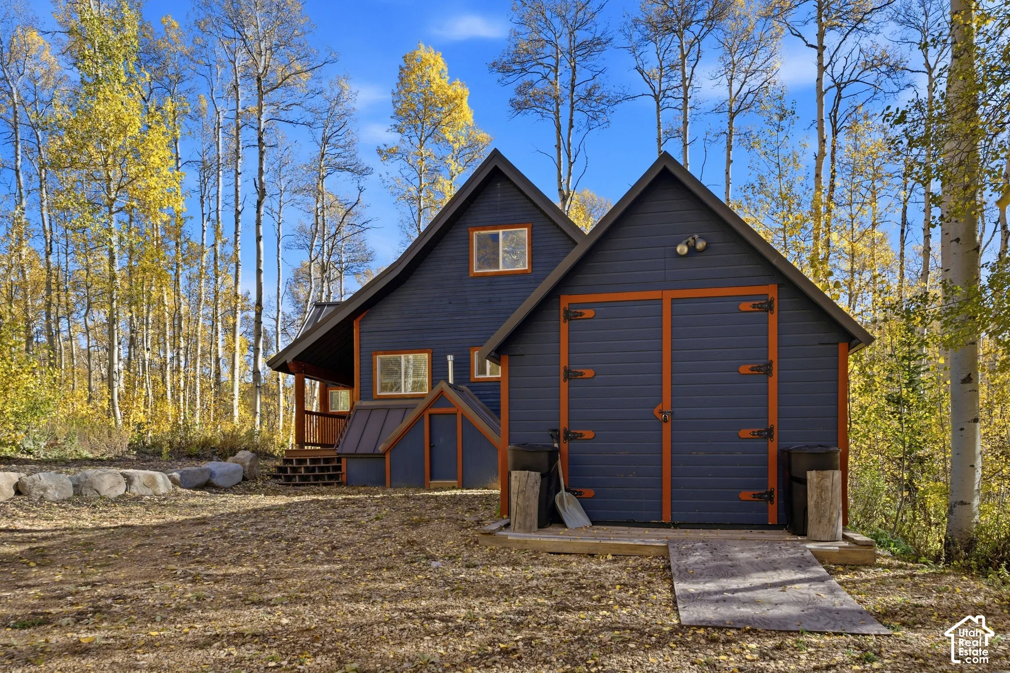 Exterior featuring horizontal siding with contrasting trim, a metal roof, and an attached storage structure