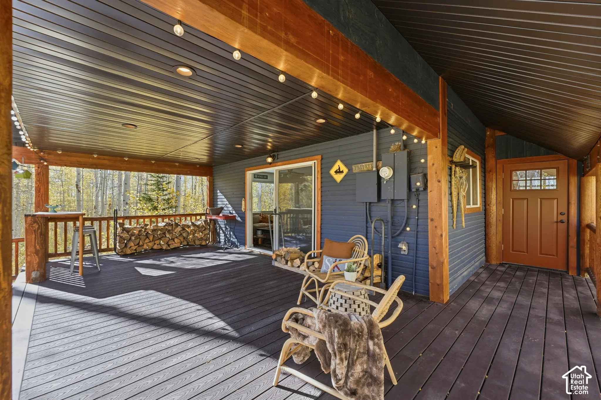Covered deck featuring wood-finish decking, exposed timber support beams, and a metal-paneled ceiling