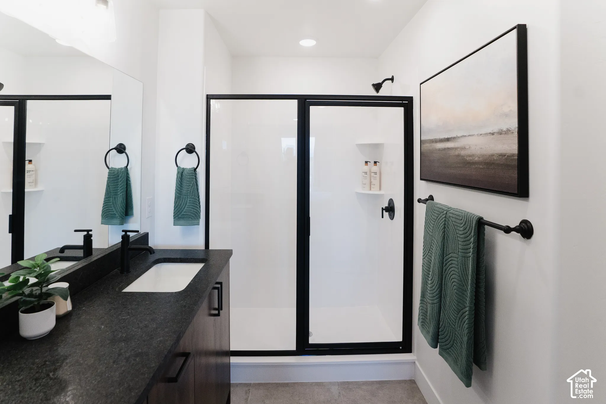 Bathroom featuring a dark wood-finish vanity with a matte black faucet, a large rectangular mirror, and a walk-in shower with a matte black frame and matching fixtures