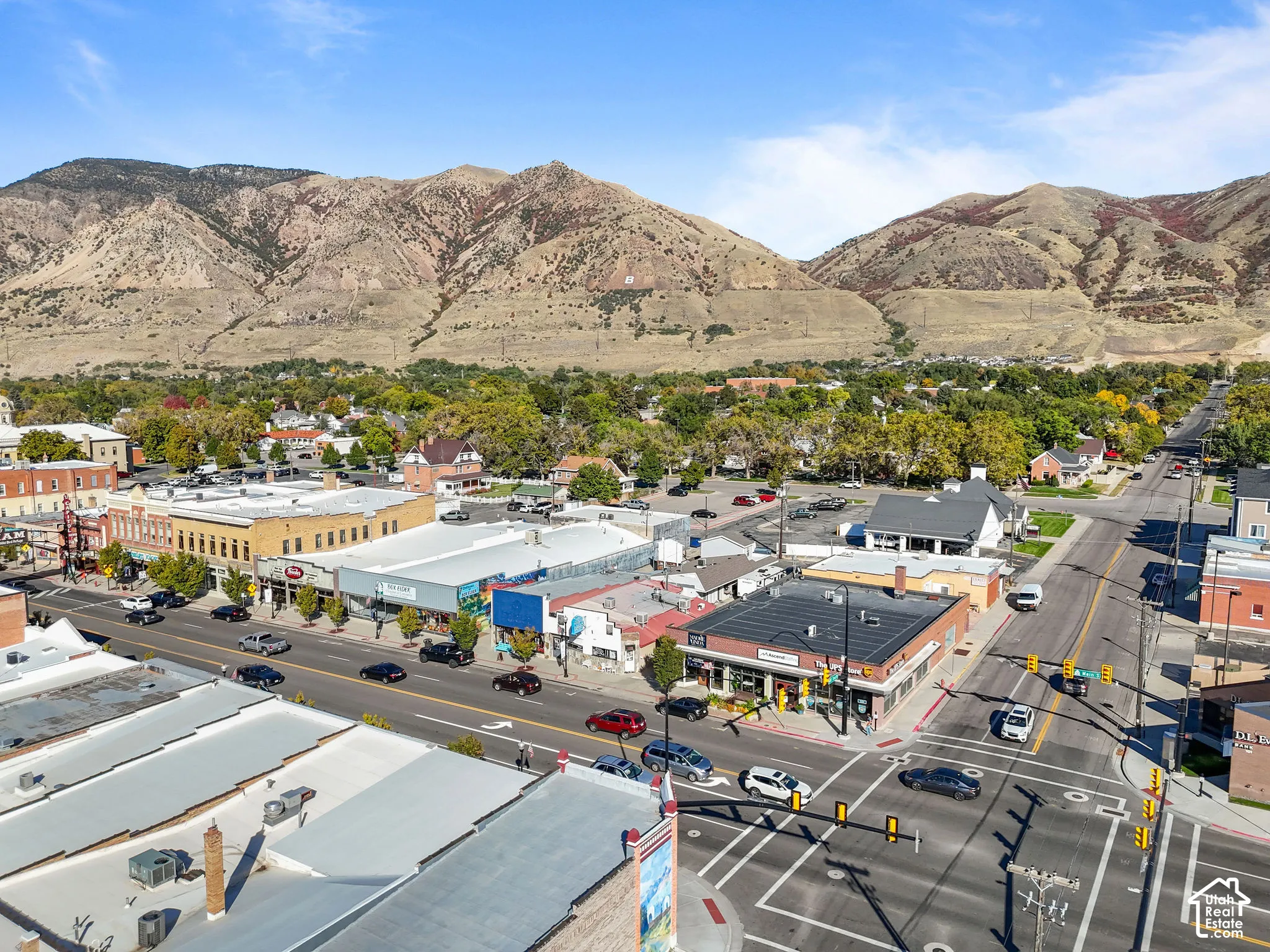 Aerial perspective featuring established urban infrastructure, prominent mountain backdrop, and direct street-level access