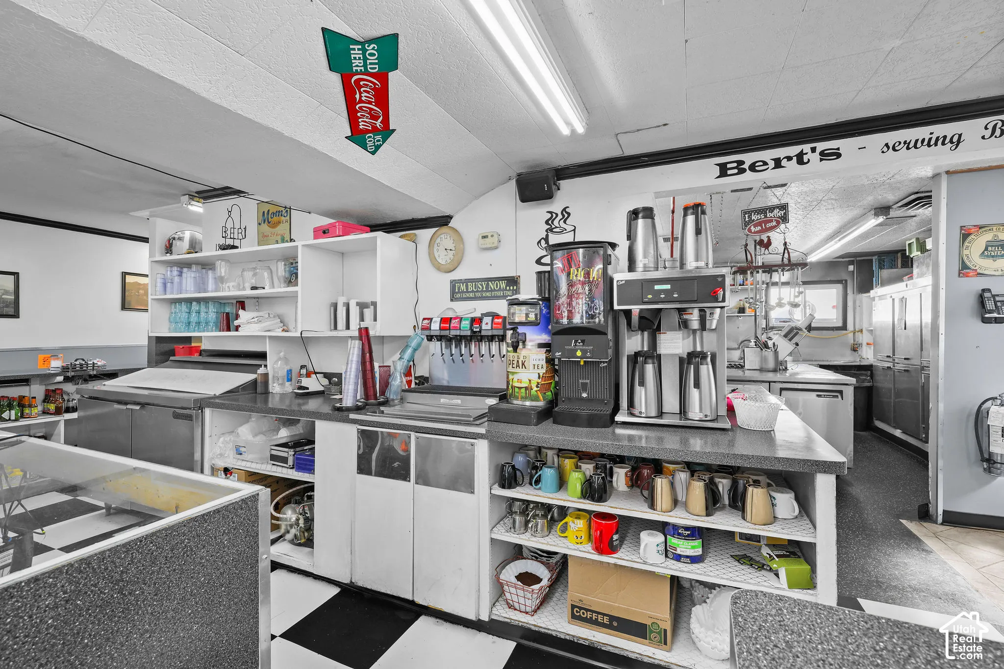Commercial service area featuring built-in cabinetry, durable grey countertops, integrated beverage dispensing system with commercial-grade coffee equipment.