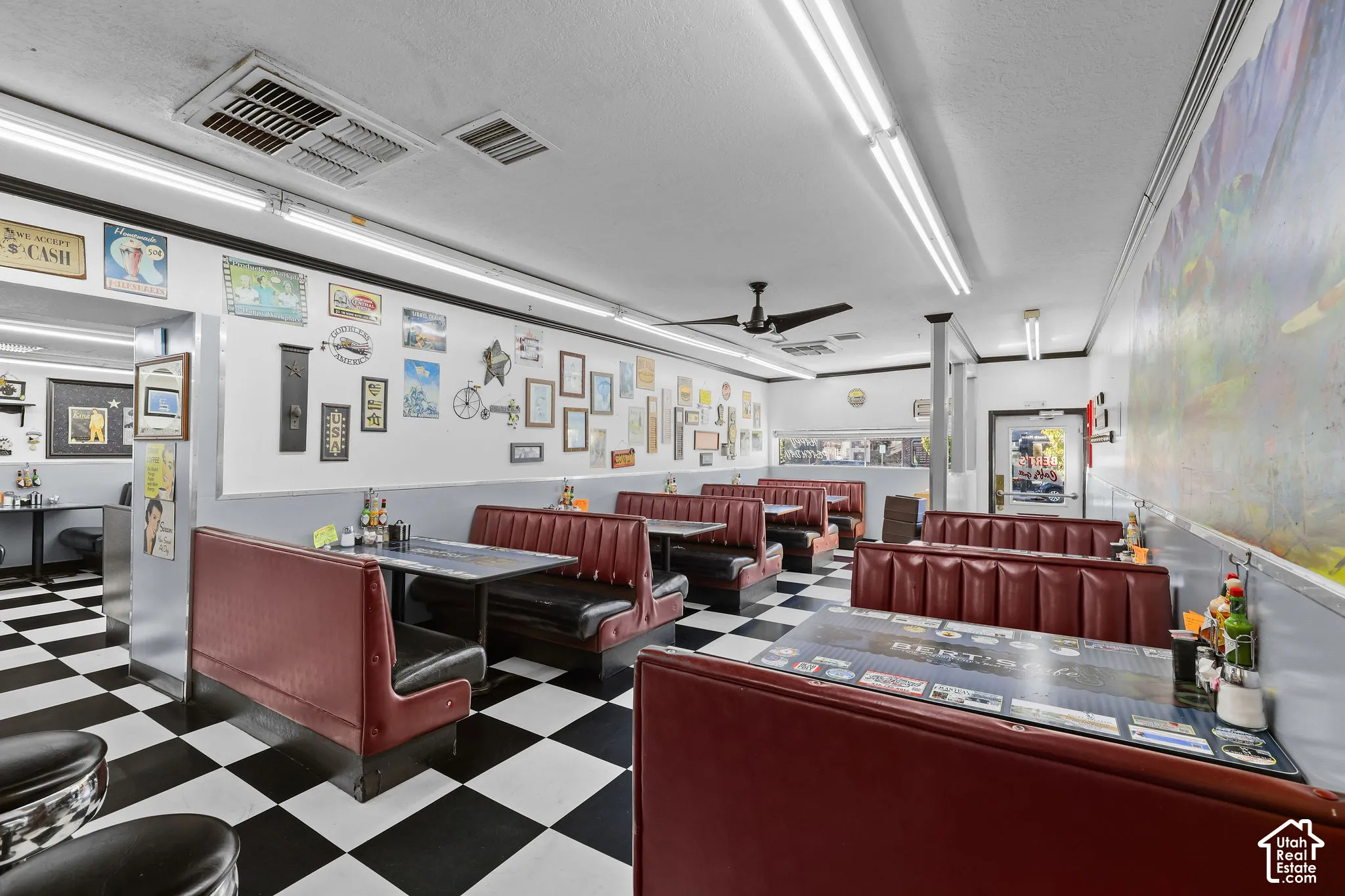 Checkerboard flooring, built-in booth seating, and ceiling-mounted light fixtures