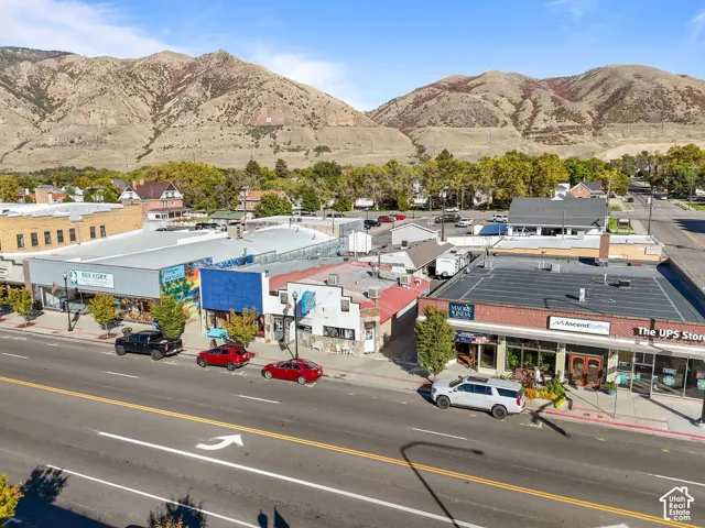 Commercial streetscape featuring brick and stucco storefronts with prominent mountain backdrop