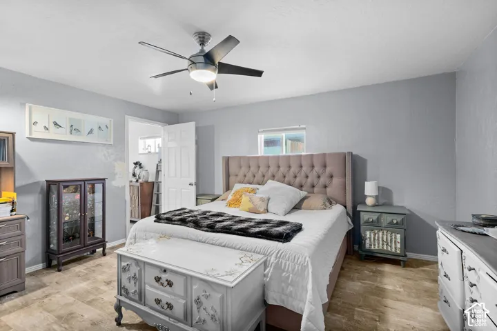 Room featuring neutral wall tones, stone-finish tile flooring, and a central brushed-metal ceiling fan with an integrated light fixture