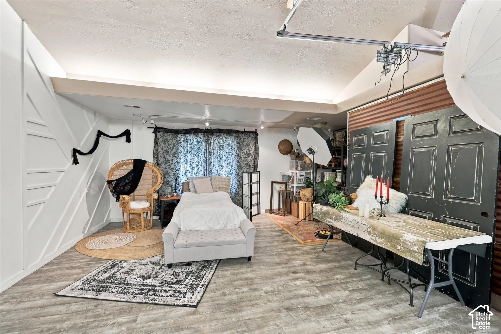 Vaulted ceiling featuring recessed lighting, wood-finish flooring, and a decorative geometric accent wall