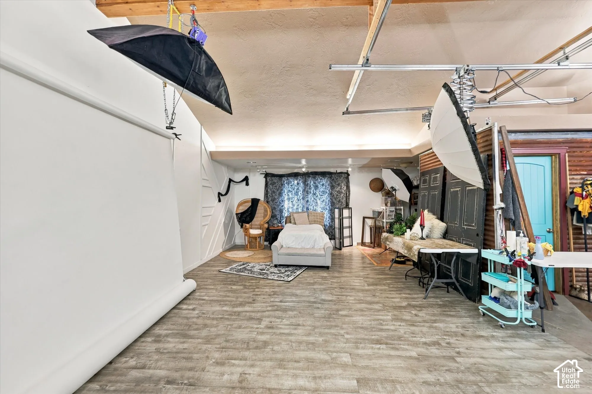 Expansive interior space featuring vaulted ceilings, exposed wooden beams, wood-finish flooring, and decorative wall paneling