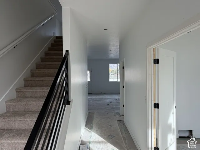 Entryway featuring a carpeted staircase with a matte black horizontal-rail balustrade and recessed ceiling lighting