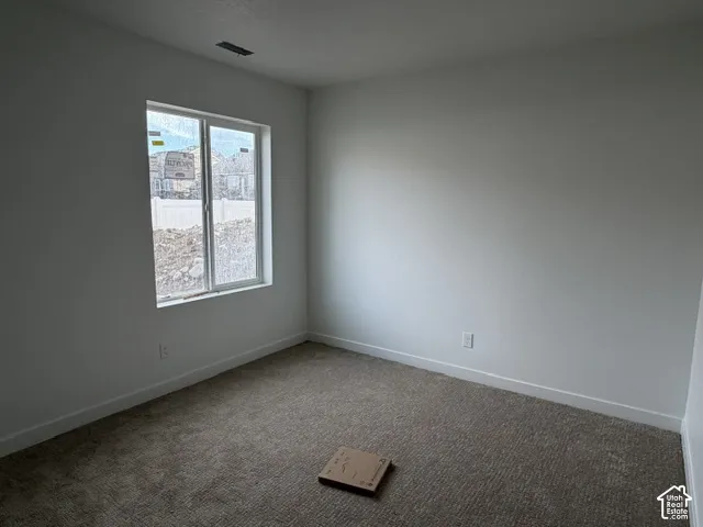 Neutral-toned wall-to-wall carpeting and single-hung window with white framing