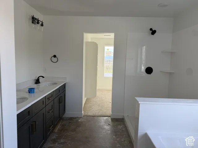 Bathroom featuring a dual-sink vanity with dark cabinetry, white countertops, matte black plumbing fixtures, and a shower enclosure with built-in shelving