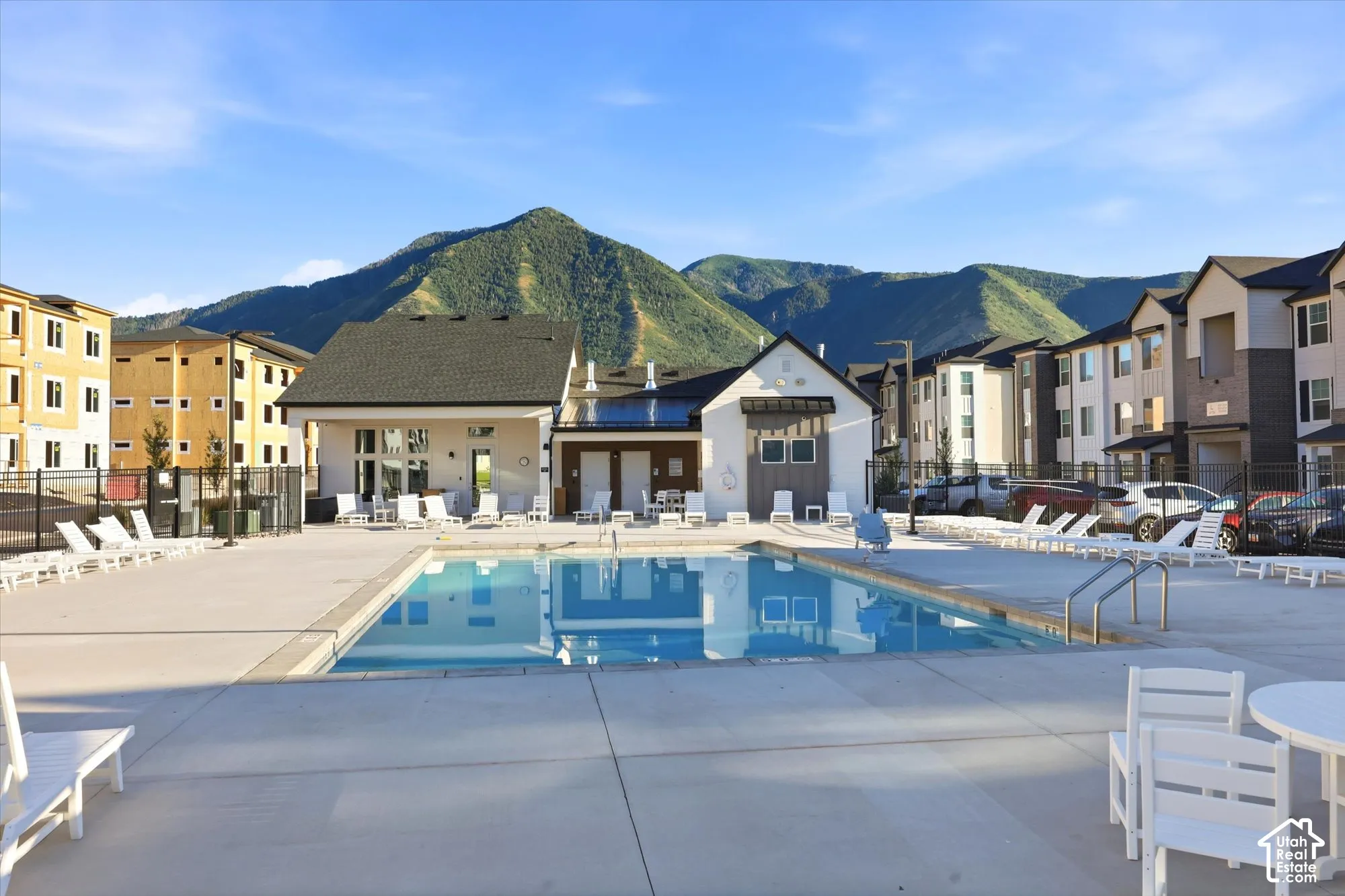 In-ground swimming pool with a concrete deck, set against a backdrop of prominent mountains