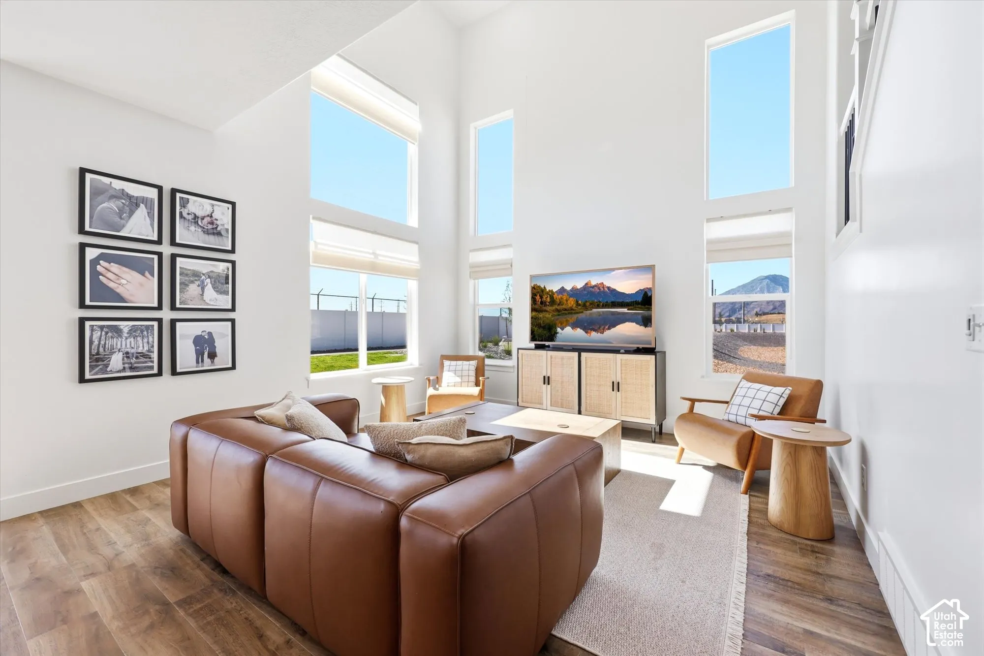 Living area featuring floor-to-ceiling windows, vaulted ceilings, and wood-finish flooring