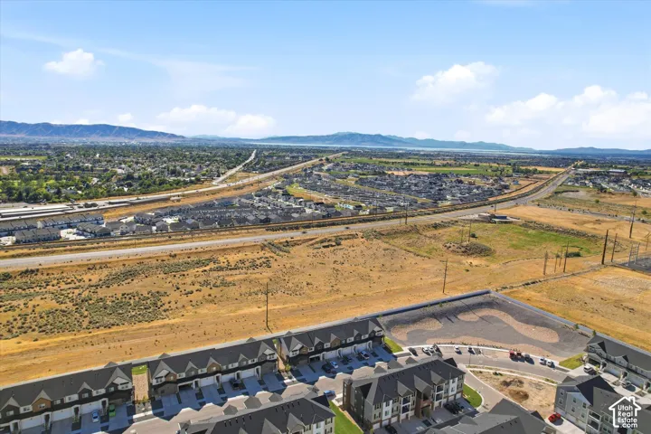 Aerial perspective featuring multi-story residential structures with pitched rooflines and surrounding mountain topography