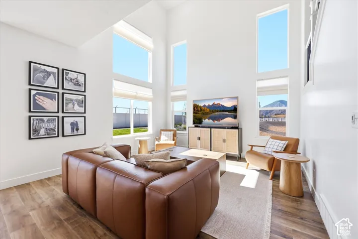 Living area featuring floor-to-ceiling windows, vaulted ceilings, and wood-finish flooring