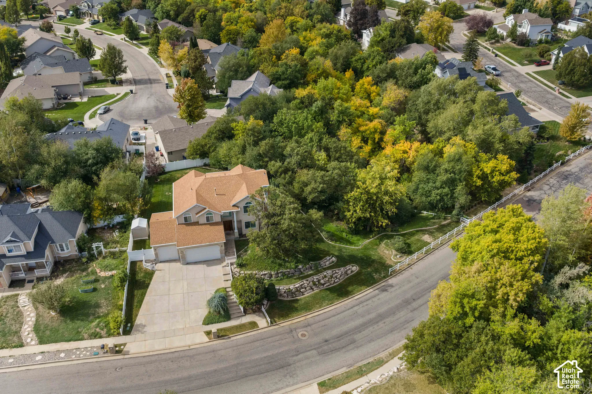 Aerial view of the front featuring mature trees