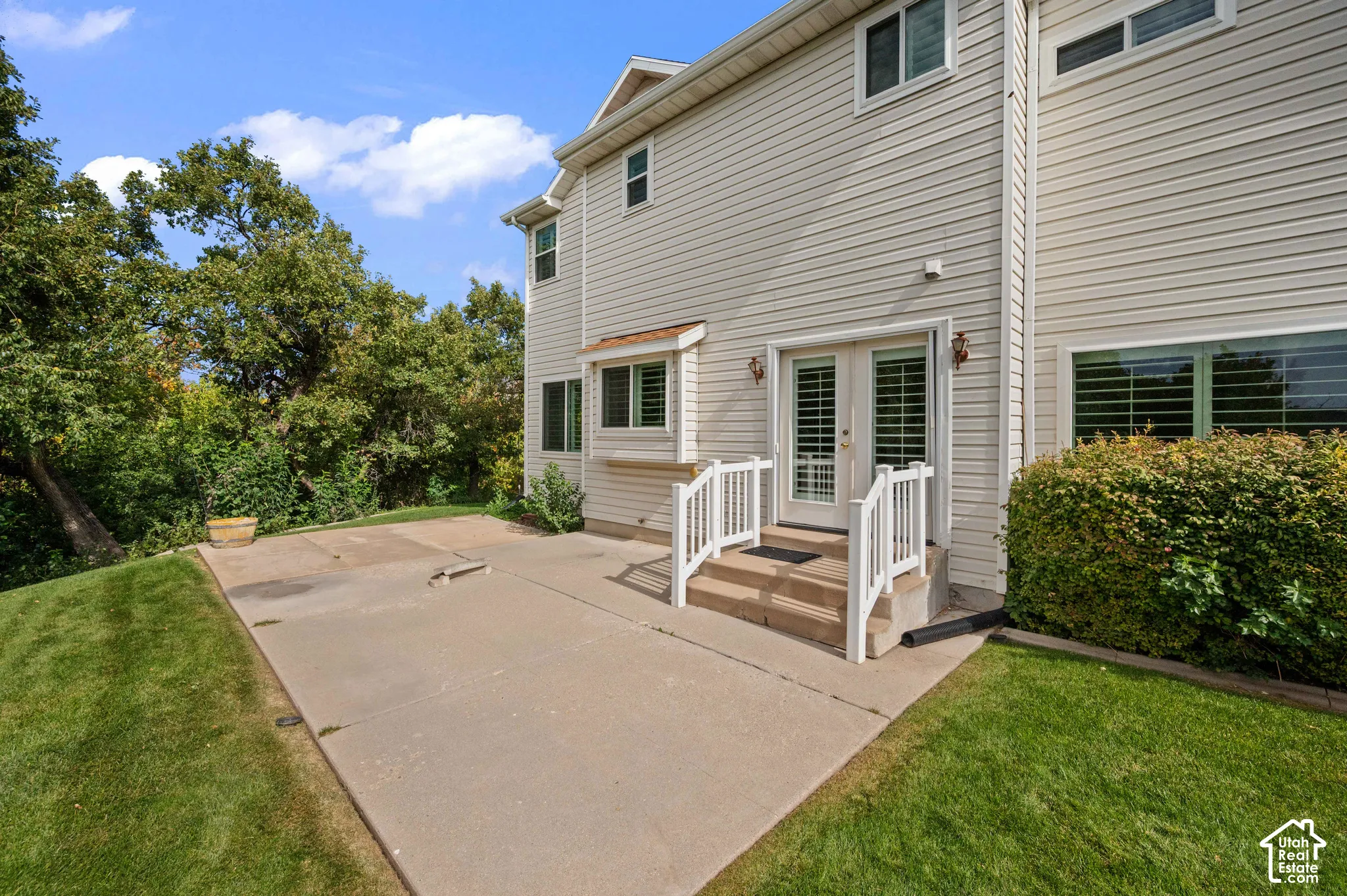 Rear view featuring a concrete patio, and double glass doors