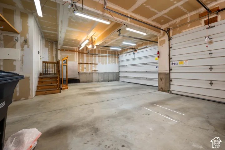 3-car garage featuring a concrete floor, and overhead fluorescent lighting