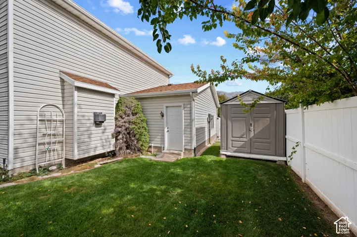 Exterior side yard featuring an exterior storage structure