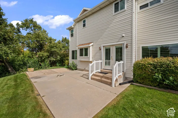 Rear view featuring a concrete patio, and double glass doors