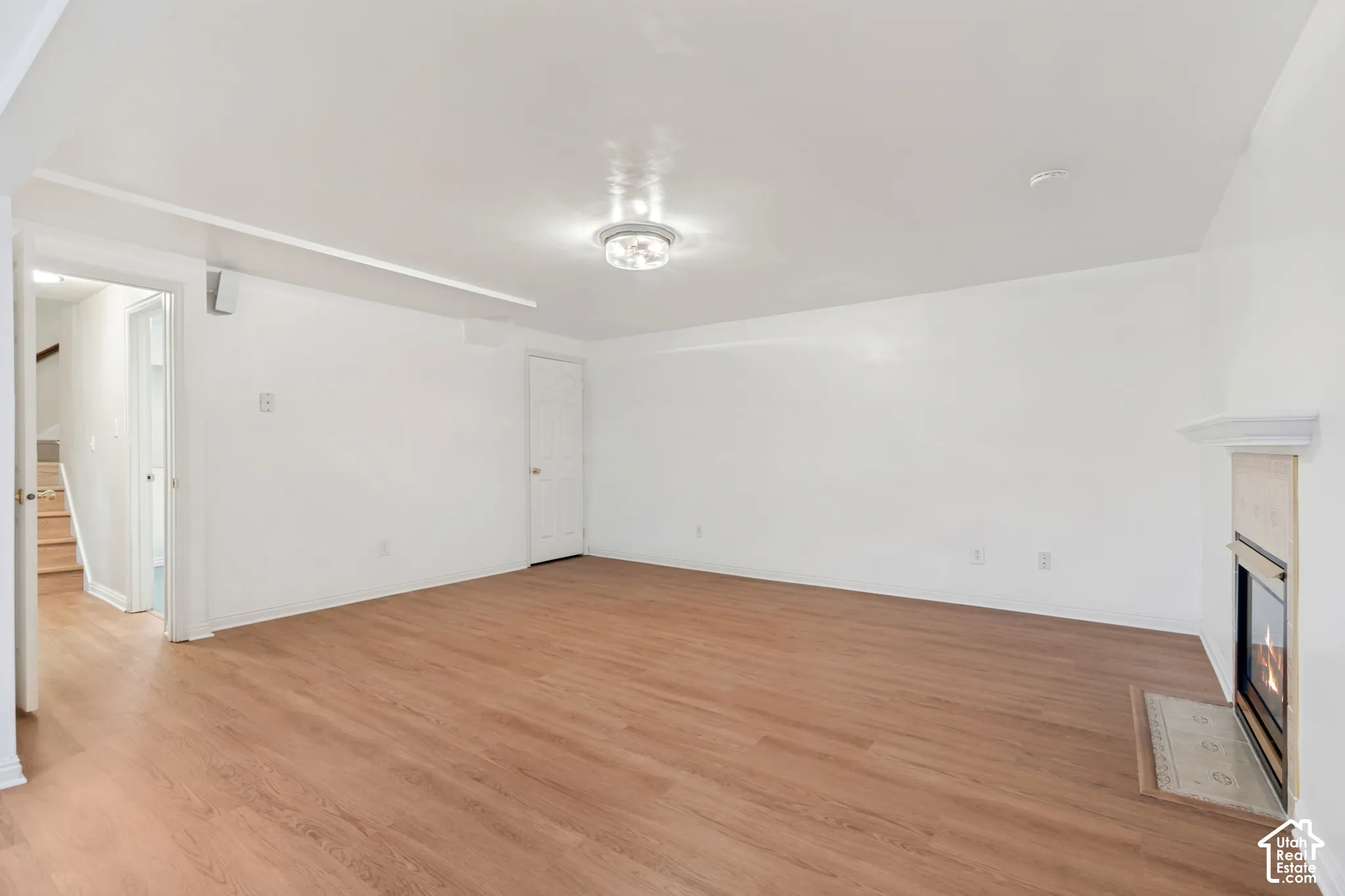 Interior space featuring wood-finish flooring, a flush-mount ceiling light fixture, and a fireplace with a mantel