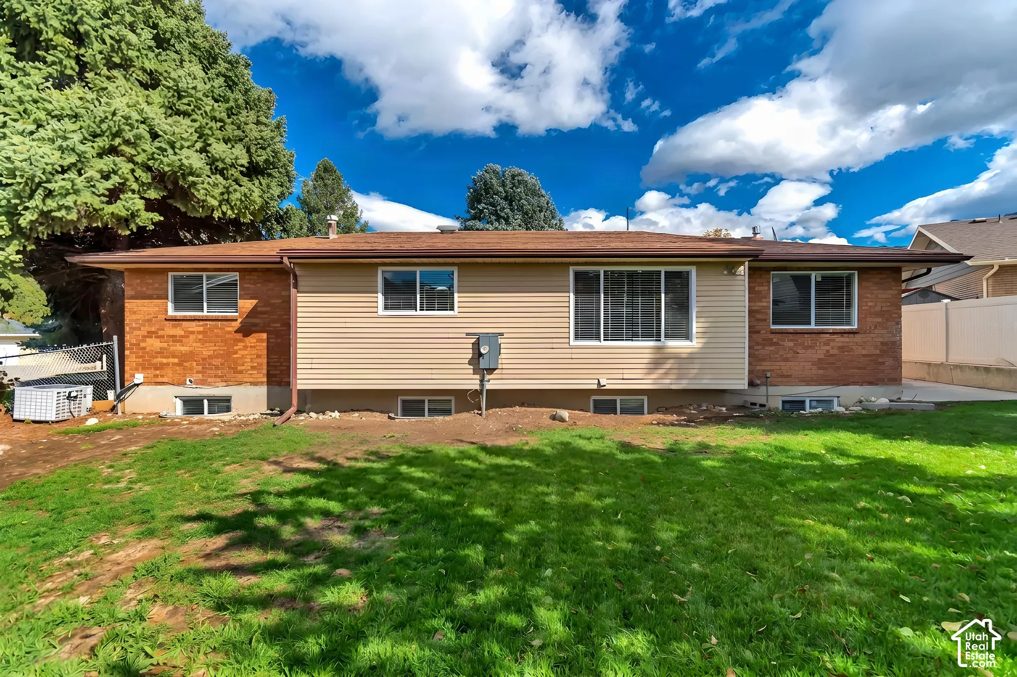 Exterior featuring a combination of brick and horizontal siding, low-pitch roofline, and multiple double-pane windows
