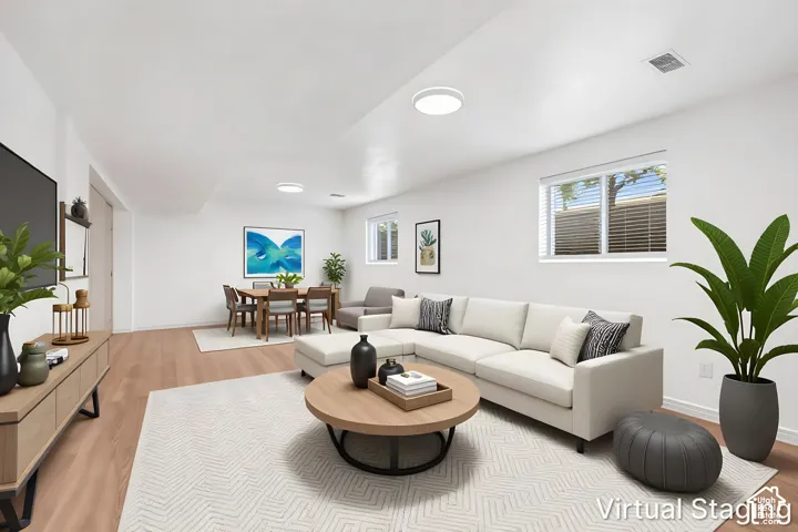 Open-concept interior featuring wood-finish flooring, recessed lighting, and multiple horizontal slider windows