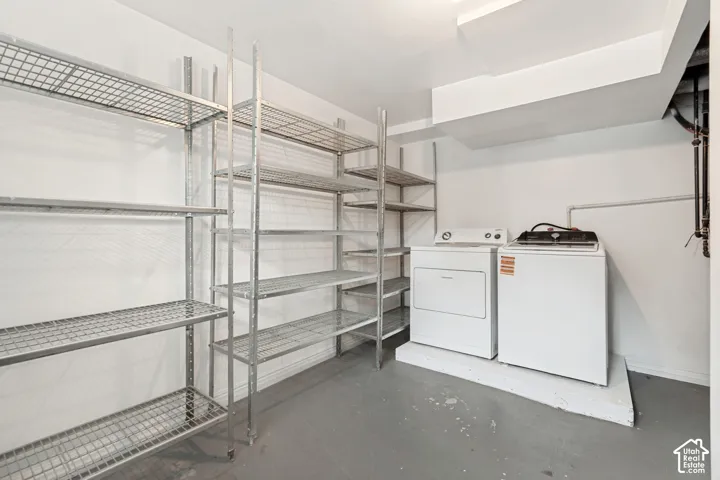 Utility room featuring metal wire shelving and a raised platform for laundry appliances