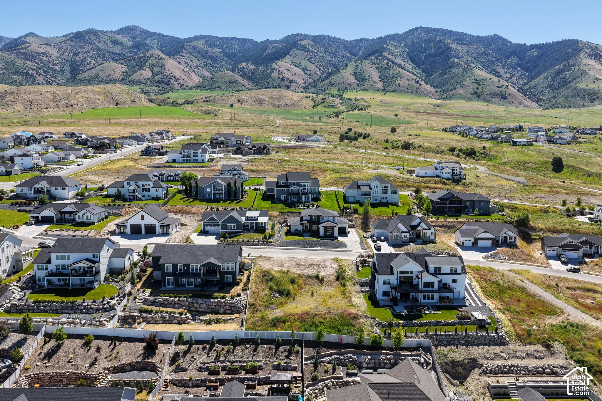 Aerial perspective featuring mountain range backdrop, expansive terrain, and residential neighborhood layout