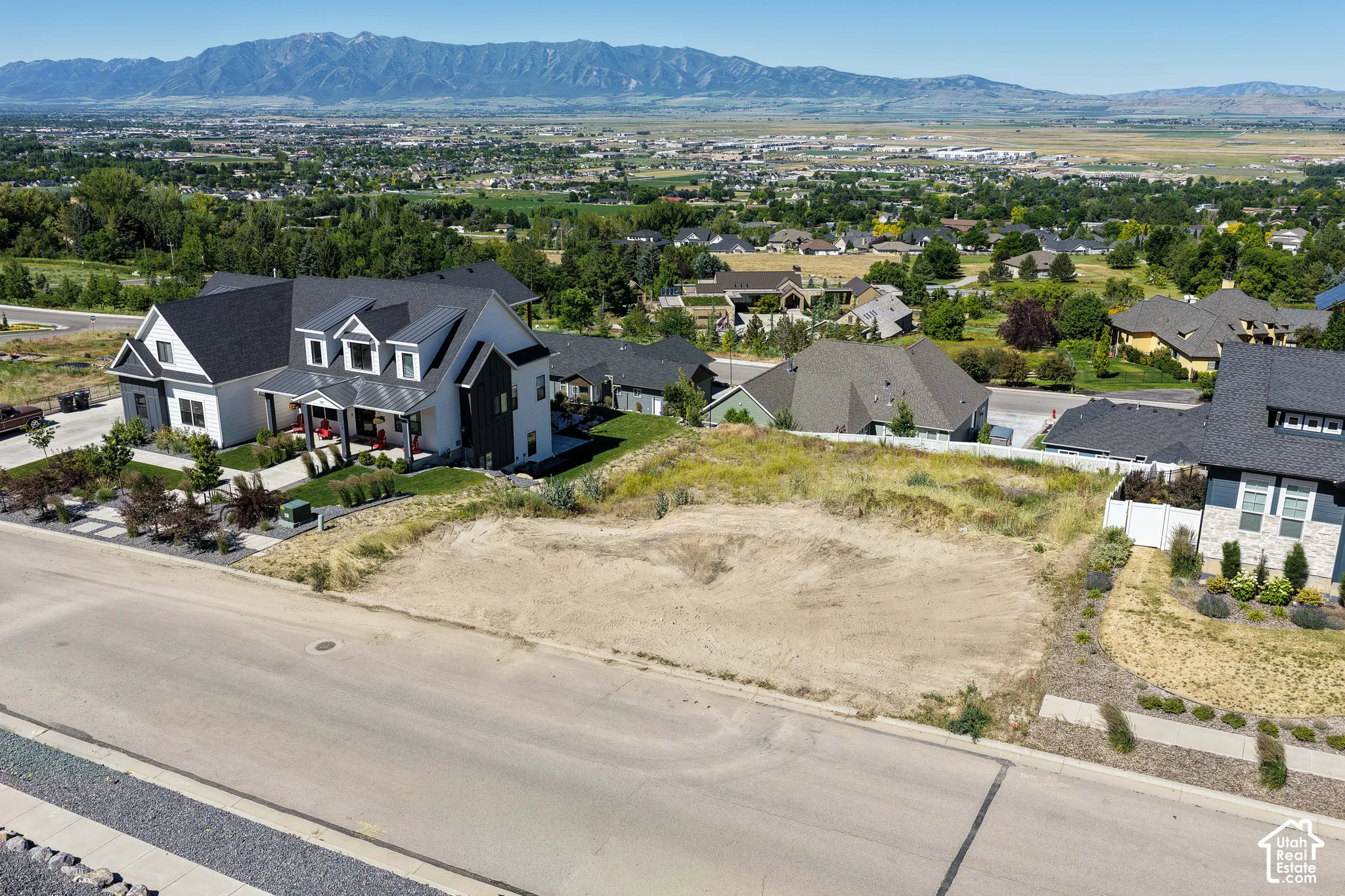 Vacant residential lot featuring elevated topography, paved street access, and expansive mountain range scenery