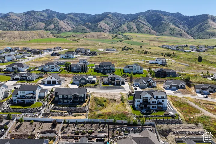 Aerial perspective featuring mountain range backdrop, expansive terrain, and residential neighborhood layout