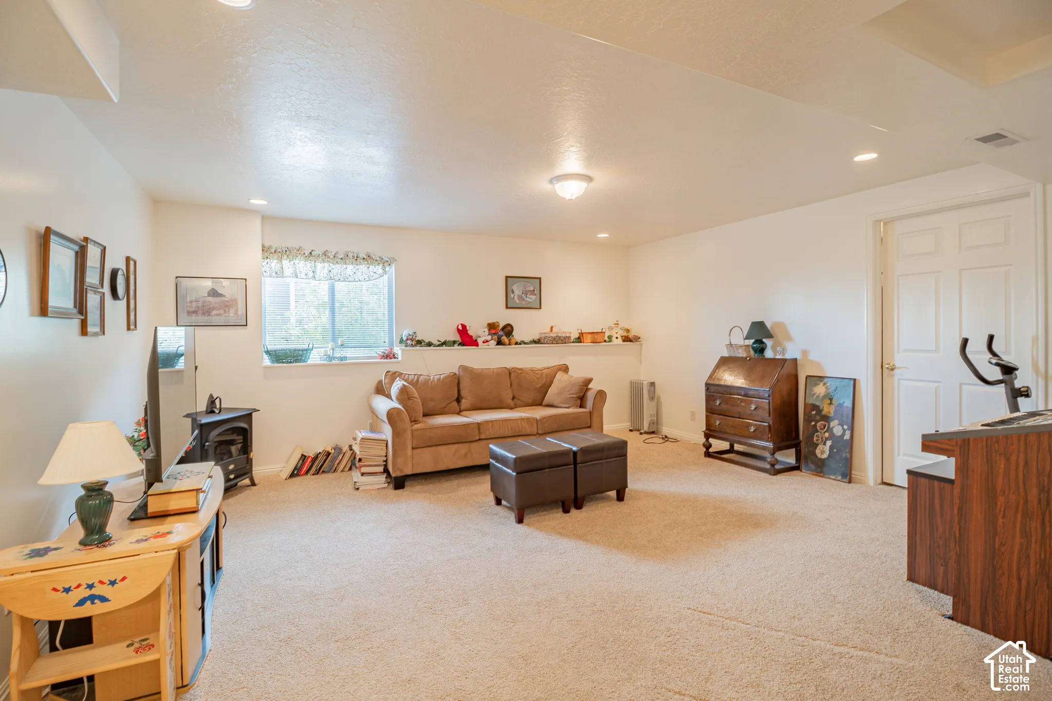 Open-concept interior space featuring neutral wall-to-wall carpeting, recessed lighting, and a built-in recessed shelf along the perimeter