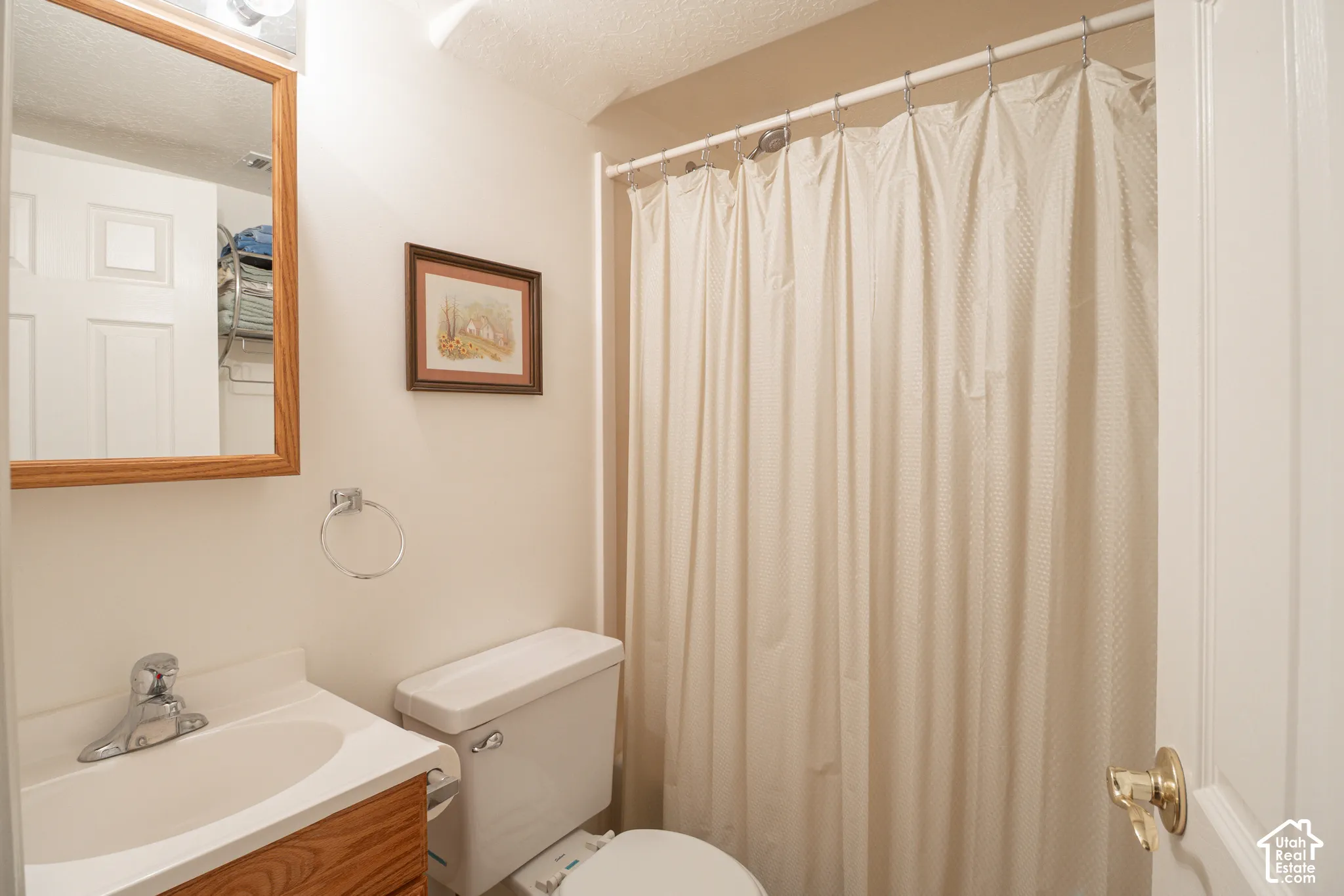 Bathroom featuring a wood-finish vanity with a molded sink, polished chrome faucet, wall-mounted medicine cabinet, and a shower-tub combination